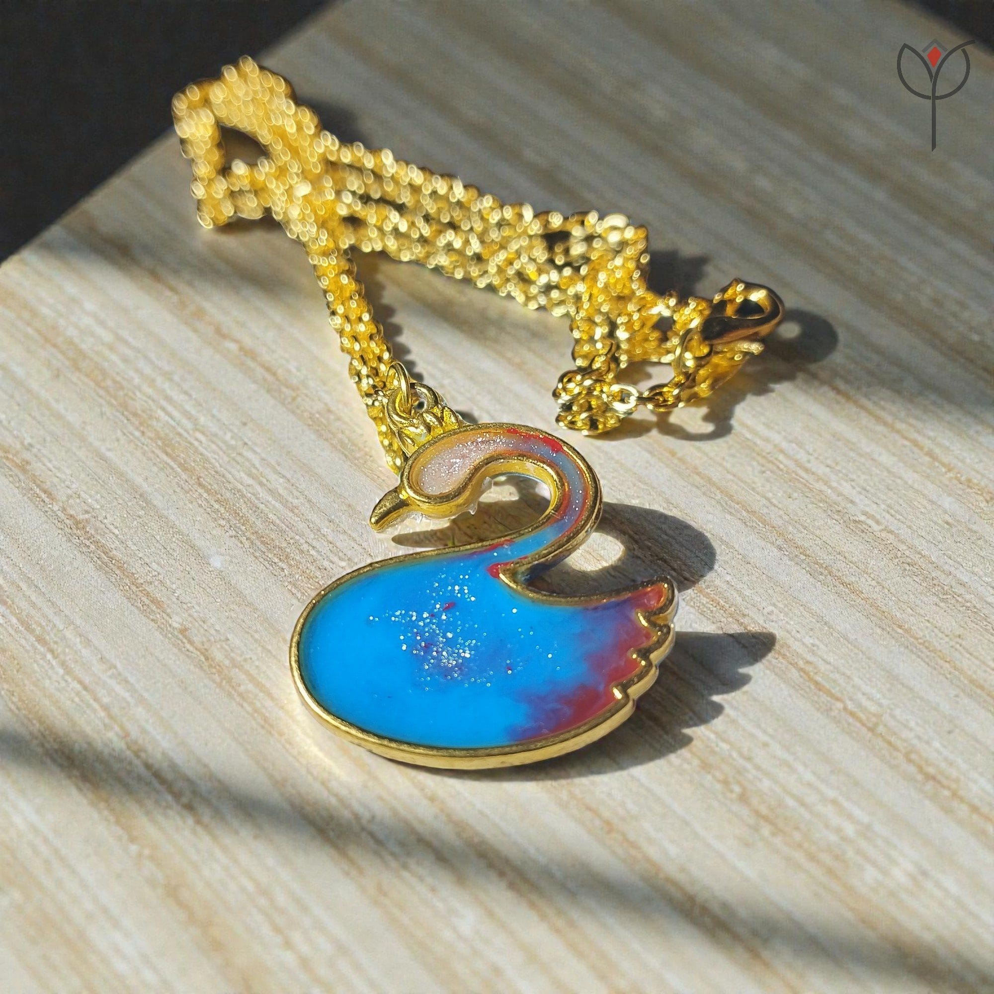 blue-swan-pendant-front-view-look Blue Swan Pendant made with blue and red resin pigment in a golden frame