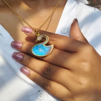 Model wearing Blue Swan Pendant on gold chain, swan-shaped resin jewellery