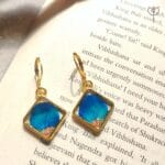 Blue Whisper Drop Earrings flat lay on book, nature-inspired resin earrings