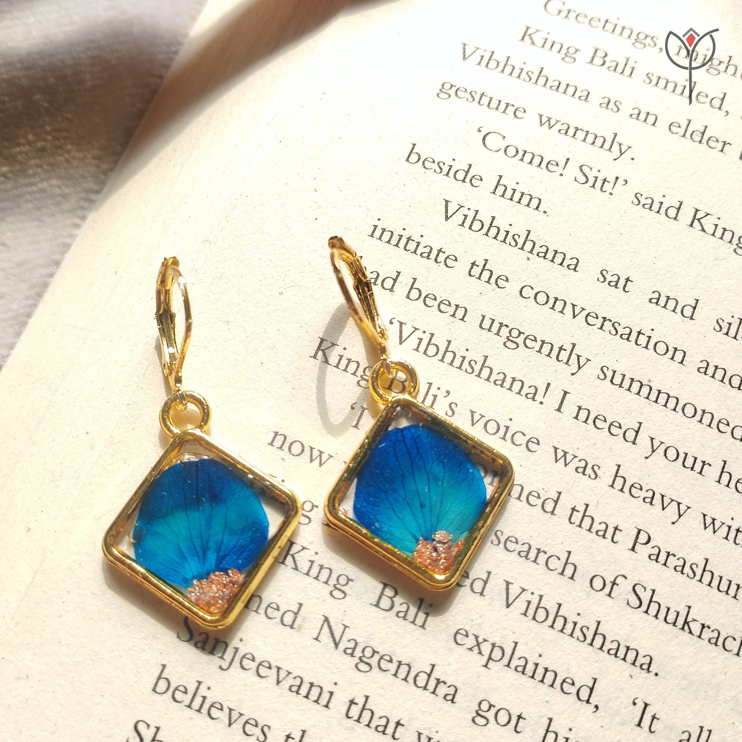 Blue Whisper Drop Earrings flat lay on book, nature-inspired resin earrings