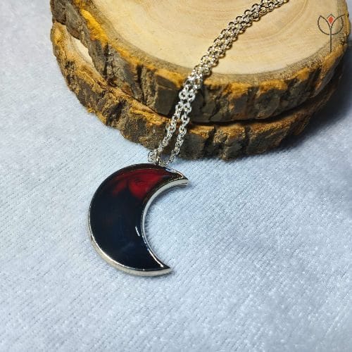 Close-up of Crimson Moon pendant in crescent moon shape