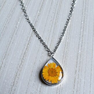 Close-up of real yellow daisy inside resin Dewbloom Pendant
