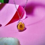 Side view of Dewbloom Pendant in stainless steel with daisy flower