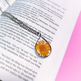 Dewbloom Pendant with real yellow daisy in teardrop resin frame