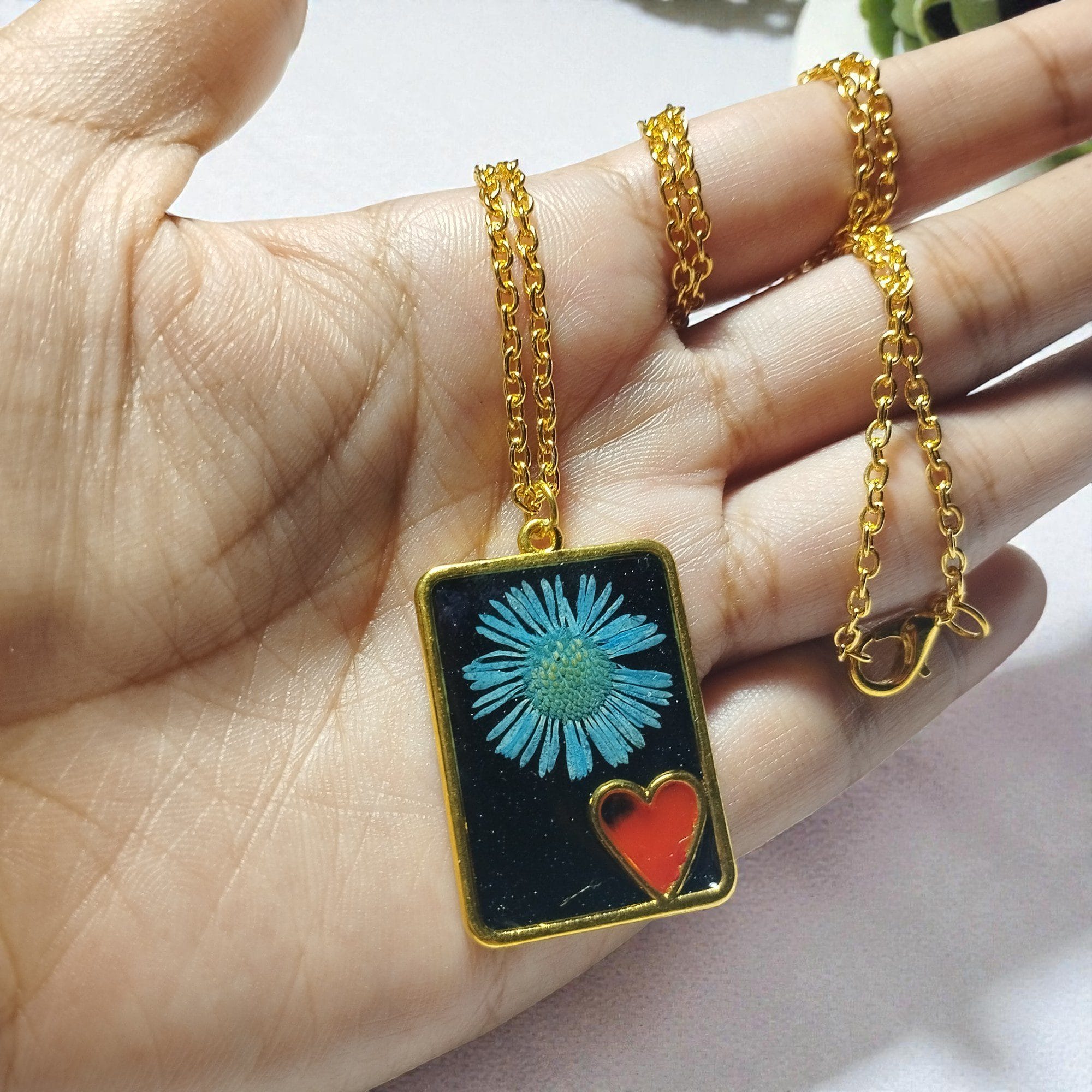 Close-up of Red Heart Bloom pendant with blue flower and red heart