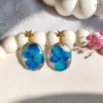 Blue floral resin drop earrings in a lightweight gold frame