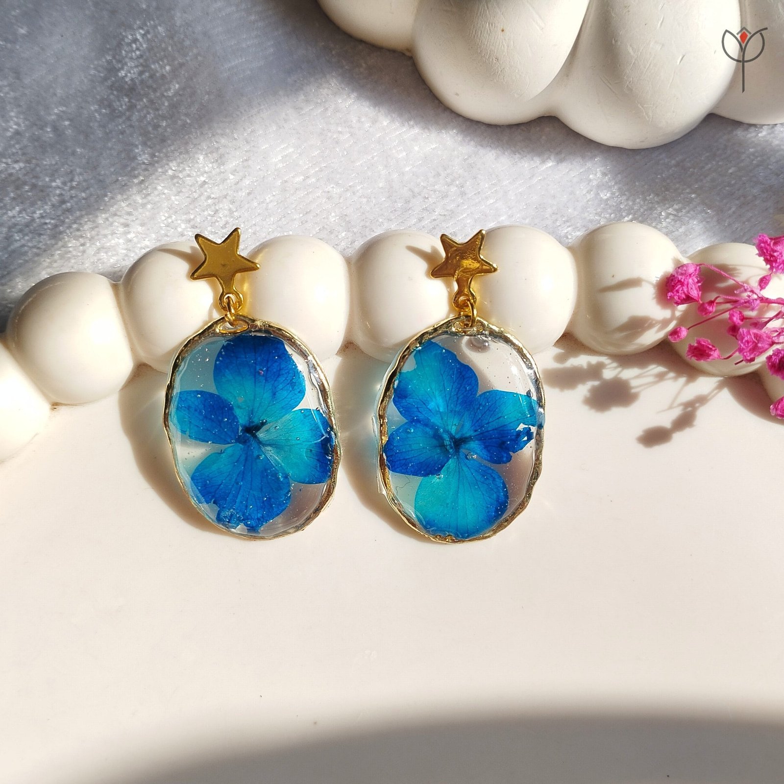 blue-resin-drop-earrings-gold-frame Blue floral resin drop earrings in a lightweight gold frame