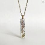 Antique style resin pendant featuring real dried flower
