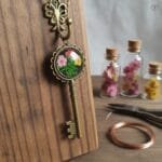 Antique style resin key pendant with colorful dried flowers