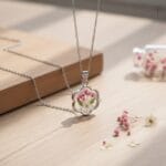 Scalloped silver pendant featuring preserved flower