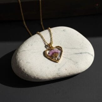 Heart-shaped gold pendant featuring real dried daisy