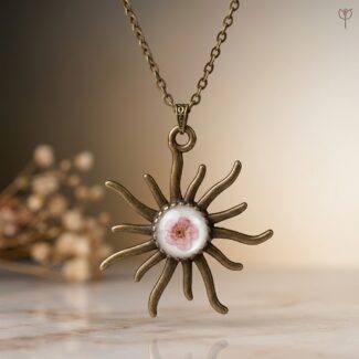 Antique Solstice Pendant featuring a pink plum flower in a bronze sunburst