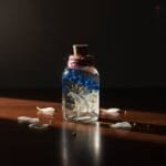 blue hydrangea and baby’s breath in clear glass bottle