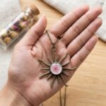 Pink plum blossom preserved in a white resin centre with antique sun rays