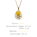 Close up of a botanical teardrop pendant on a gold chain