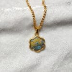 Flower-shaped gold pendant with blue and yellow impressionist floral pigments