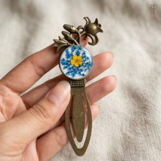 Resin bookmark with a sapphire blue flower halo and yellow centre