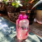 Preserved flower bottle with gold key charm and hot pink twine