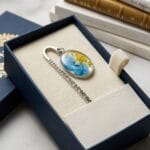 Silver shepherd’s hook bookmark featuring real blue petals and a white pear