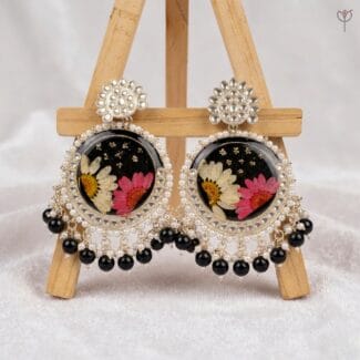 Dusk Daisy Kundan Jhumka featuring real pink and white daisies in black resin