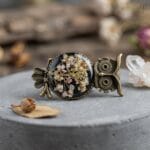 Sora Ring featuring a vintage owl and real white wildflowers in resin