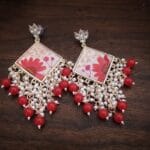 Close up of Kaira jhumka featuring kundan stones and real red daisy petals preserved in premium resin