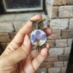 Close up of a purple pansy floral ring with high-quality resin