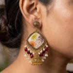 Model wearing the Gilded Lace Meadow Resin Jhumka, showing the diamond-shaped drop and maroon bead tassels.