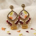Gilded Lace Meadow Resin Jhumka with pressed aster and Queen Anne's lace set in ivory resin, framed in golden oxidised metal.
