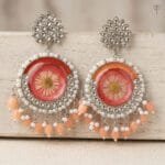 Sundried Aster Resin Jhumka with a pressed aster flower set in coral resin, framed in silver kundan with pearl beading.