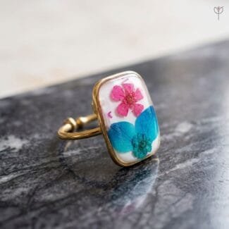 Fae Garden Ring with dried plum flower and blue hydrangea set in resin with gold-tone anti-tarnish band by Mystik Falls