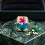 Fae Garden Ring worn on hand showing dried plum flower and hydrangea botanical resin setting