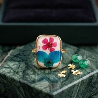 Fae Garden Ring worn on hand showing dried plum flower and hydrangea botanical resin setting