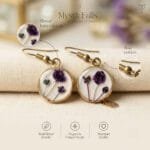 Close-up of Lavinia Resin Earrings showing dried purple baby's breath stems preserved in clear resin within a round antique gold bezel