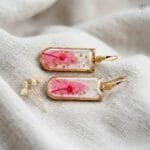Pair of Liora Resin Earrings with preserved pink leaf and gold foil in rectangular resin pendants set in golden frames by MystikFalls