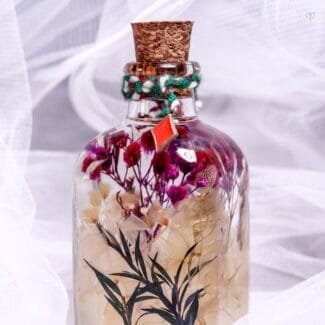 Miniature Botanical Glass Garden close-up of tiny real preserved flowers and greenery floating in mineral oil