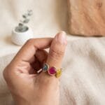 Mystic Trio Resin Ring placed on dark wooden surface with dried flowers and crystal in the background