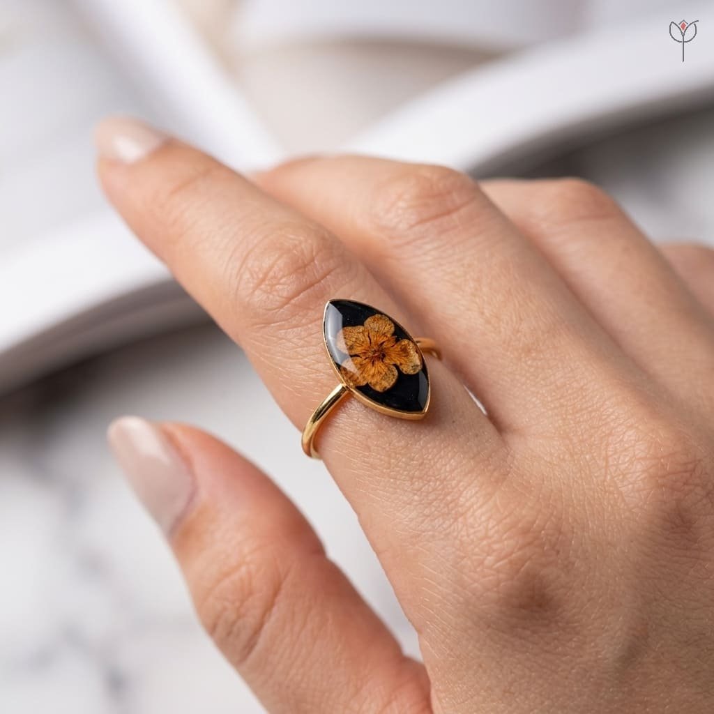 obsidian-bloom-ring-worn-on-hand-botanical-resin-jewellery Obsidian Bloom Ring worn on hand showing dried plum flower in black resin with adjustable gold band