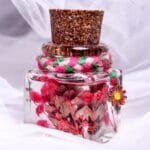 Rosita Preserved Flowers Glass Garden displayed as colourful mini botanical desk decor on a wooden log stand