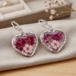 Valentina Bloom Earrings featuring preserved plum flower and baby's breath in a heart-shaped resin pendant with silver wire-wrapped setting by MystikFalls