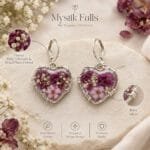 Pair of Valentina Bloom Earrings in heart-shaped resin with preserved plum flower and baby's breath set in silver wire-wrapped frames by MystikFalls
