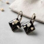 Vesper Resin Earrings featuring preserved white baby's breath in black resin diamond-shaped pendants with antique lever-back hooks by MystikFalls